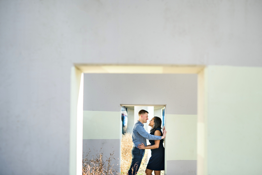 A couple stand under a framed wall during their Philadelphia Engagement Session.